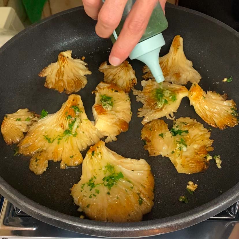 setas de ostra haciendose en una sartén a la plancha
