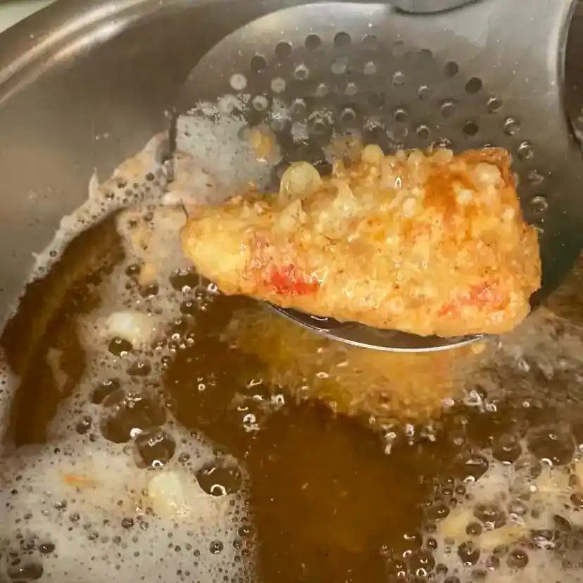 Un pimiento relleno friéndose, como paso de la receta de pimientos rellenos de carne