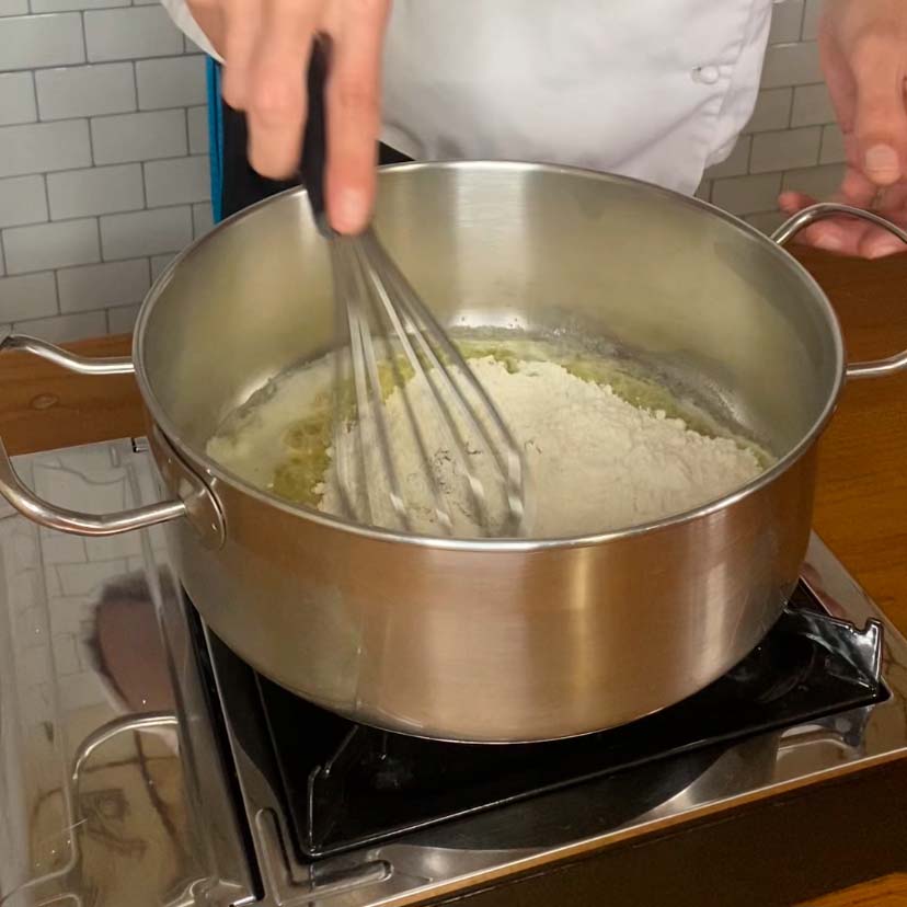 harina cocinándose con mantequilla para hacer una receta de salsa bechamel casera
