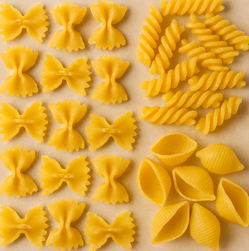 un monton de pasta de los tipos farfalle, fusilli, conchiglie, listos para acompañarlos de salsas para pasta